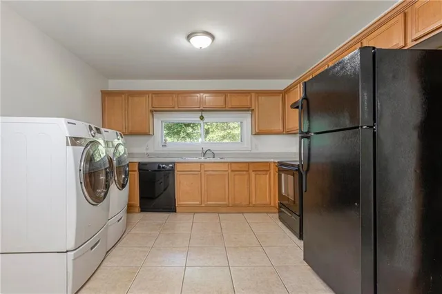 a kitchen with a refrigerator and a washer dryer