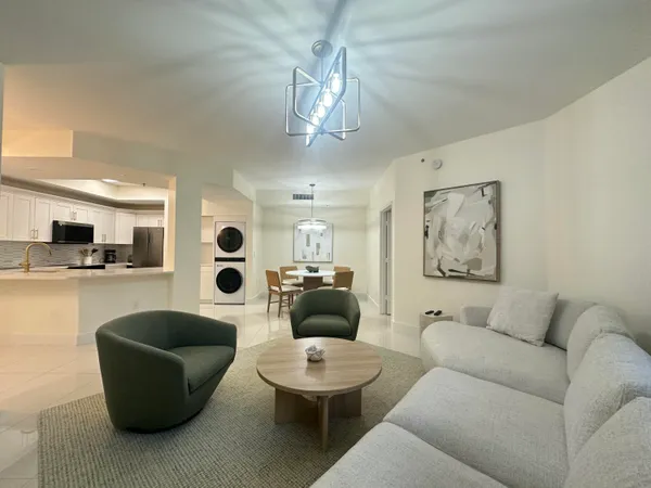 a living room with furniture and a view of kitchen
