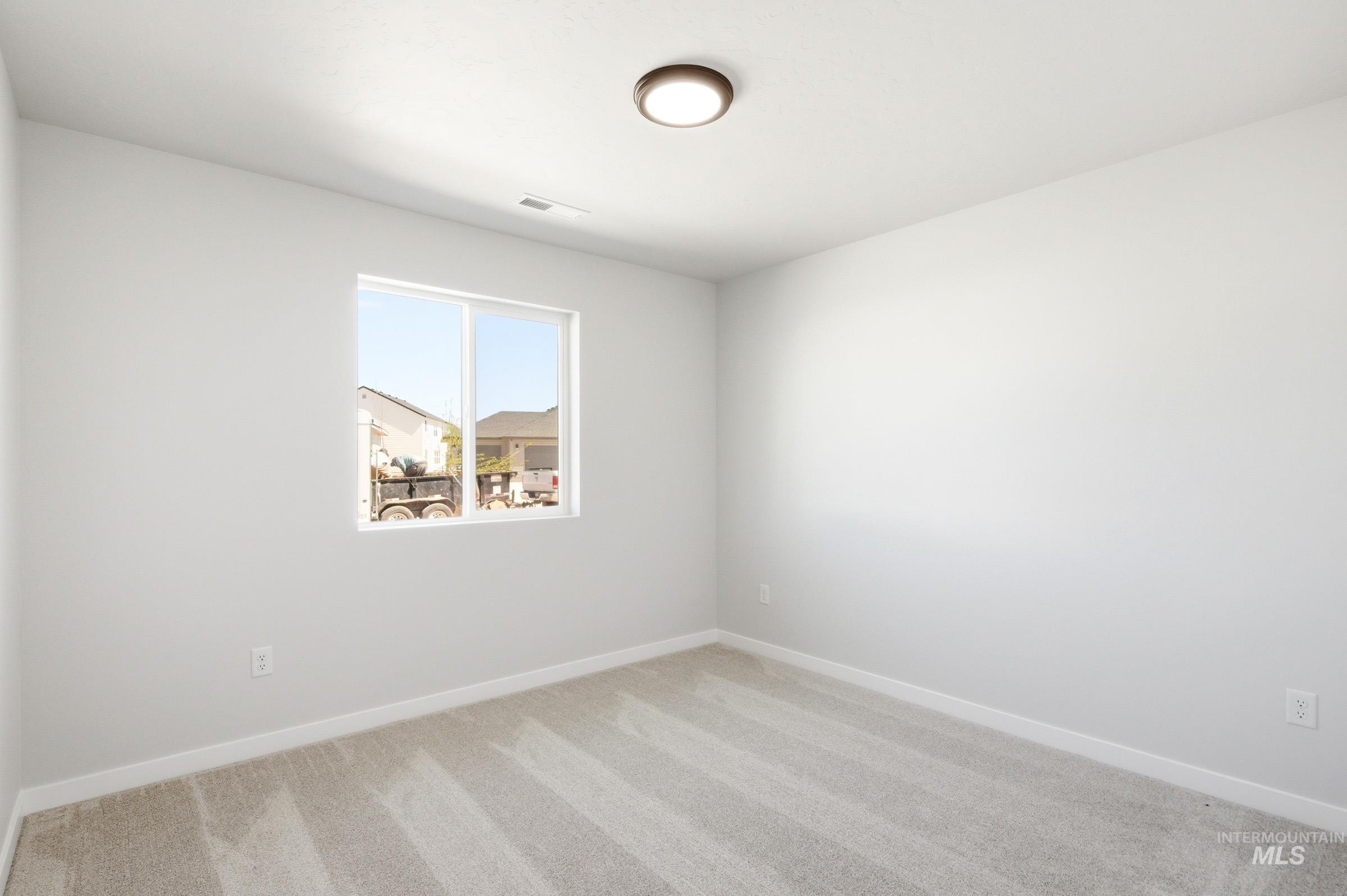 12817 Decatur Street Nampa, ID 83651 - Photo 12 of 19 Bright room featuring a single window, light-toned carpeting, white baseboards, and a flush-mount ceiling light fixture