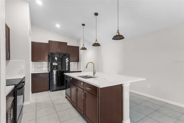 a kitchen with a sink a refrigerator and a stove