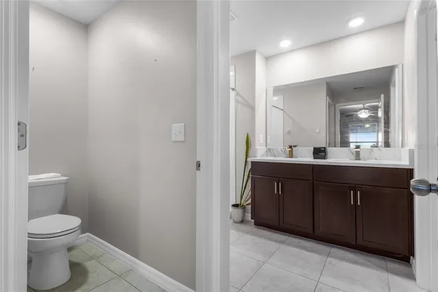 a bathroom with a granite countertop sink a toilet and a mirror