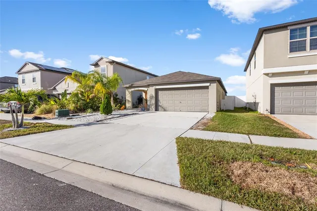 a front view of a house with a yard and potted plants