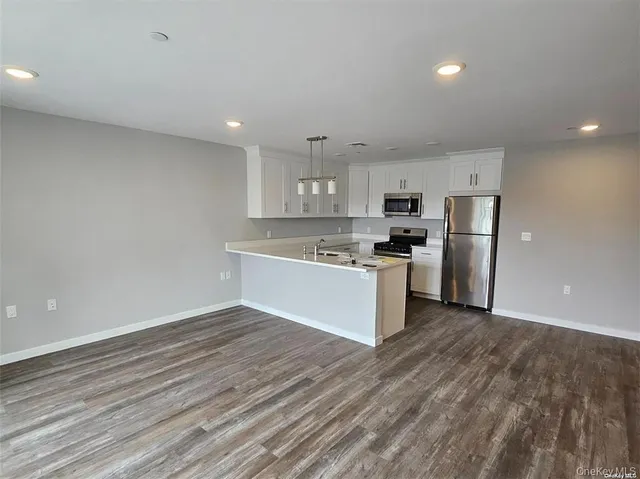 a view of kitchen with granite countertop cabinets and refrigerator