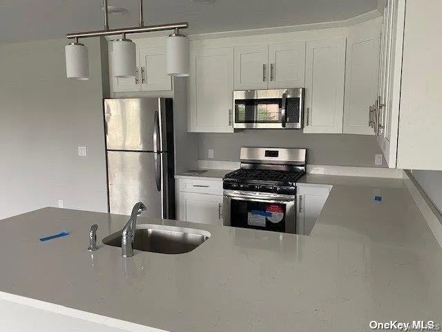 a kitchen with stainless steel appliances a refrigerator stove and microwave