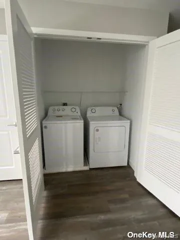 a utility room with wooden floor washer and dryer