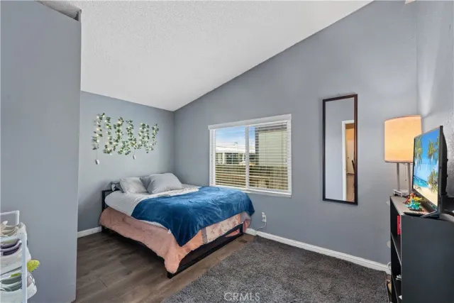 a bedroom with a bed and a flat tv screen on a dresser