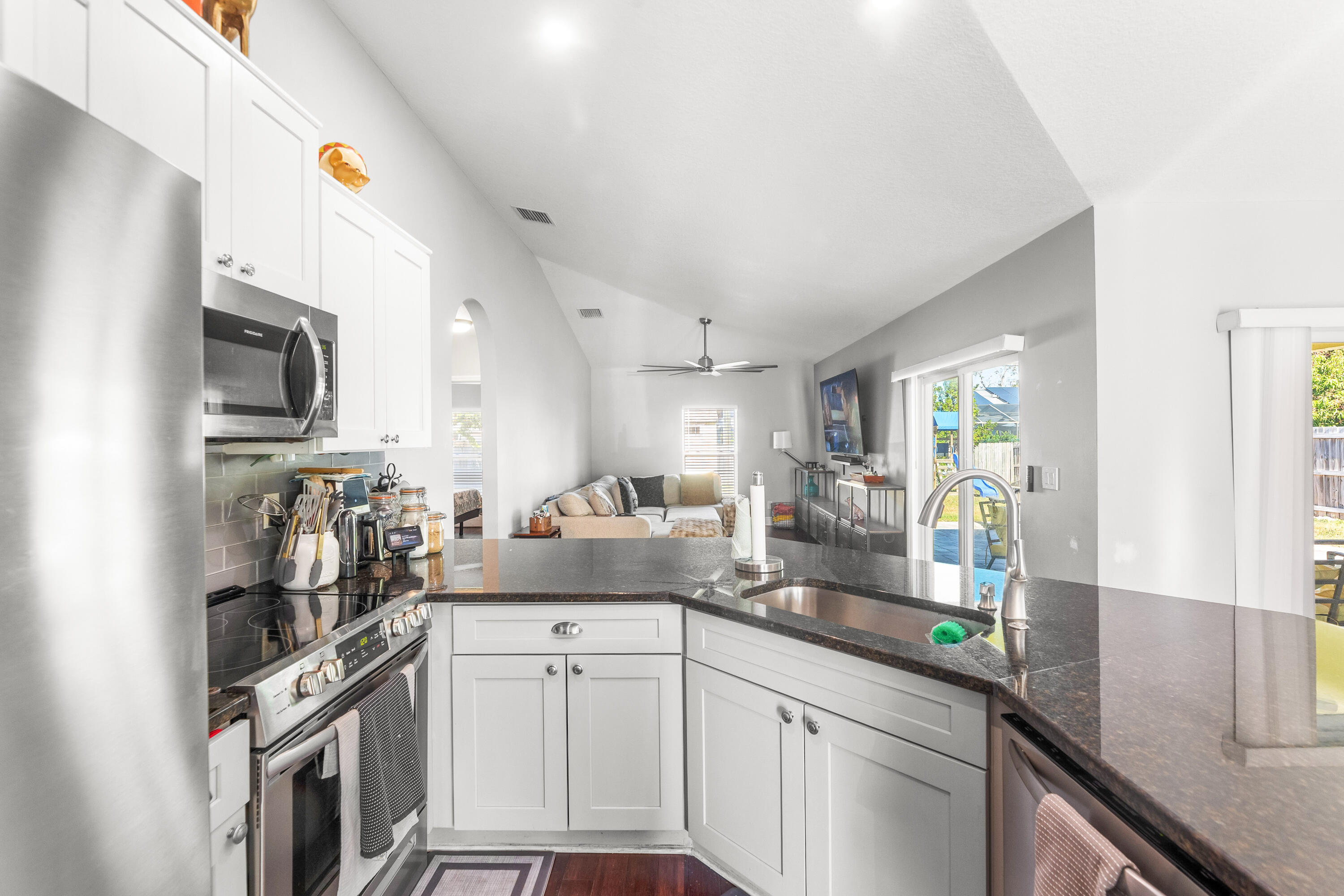 3037 Southeast Iris Street Stuart, FL 34997 - Photo 12 of 36 a kitchen with granite countertop a sink stainless steel appliances and counter space
