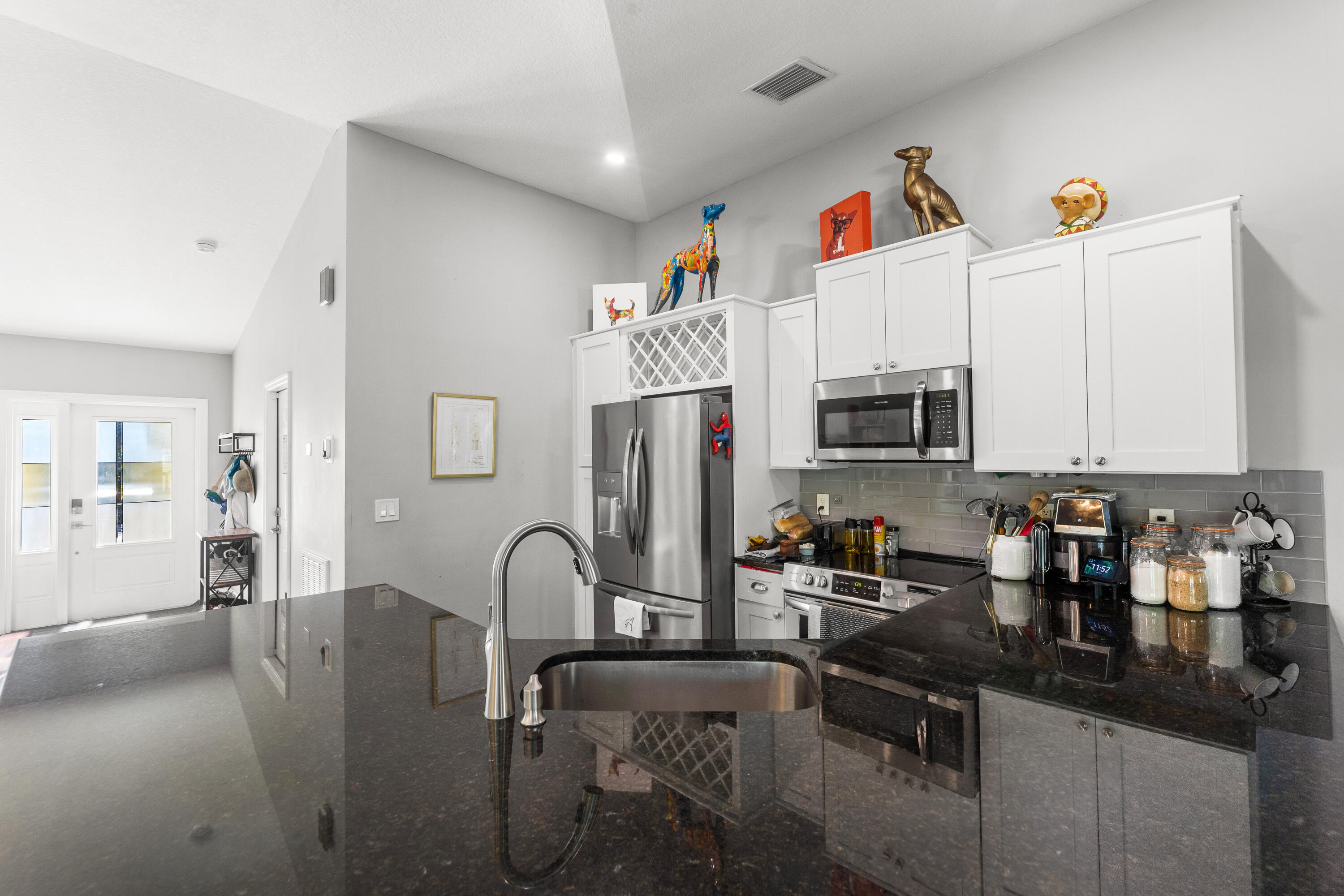 3037 Southeast Iris Street Stuart, FL 34997 - Photo 13 of 36 a kitchen with stainless steel appliances granite countertop a sink and cabinets