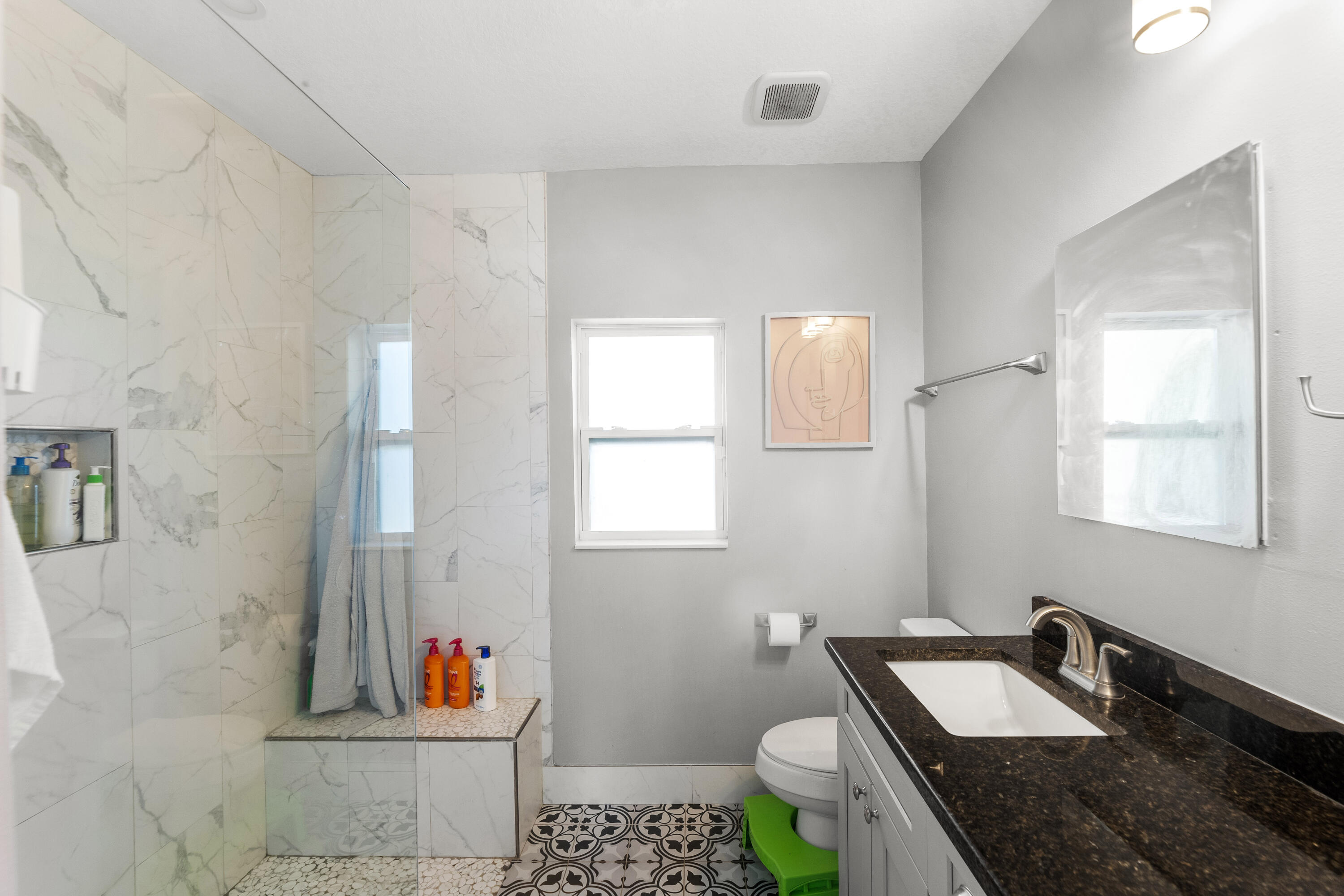 3037 Southeast Iris Street Stuart, FL 34997 - Photo 19 of 36 a bathroom with a granite countertop sink a toilet and shower