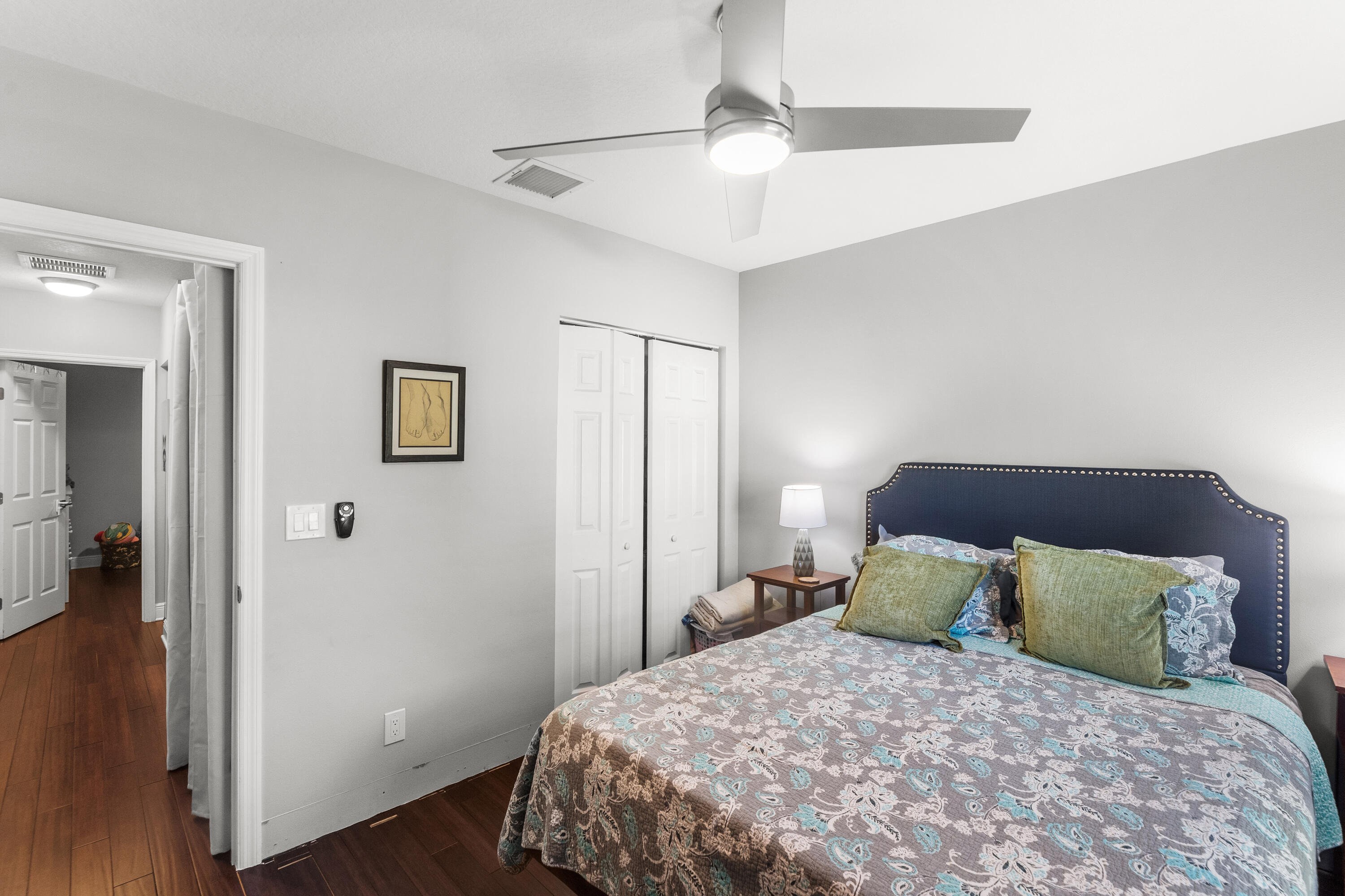 3037 Southeast Iris Street Stuart, FL 34997 - Photo 25 of 36 a bedroom with a bed and wooden floor