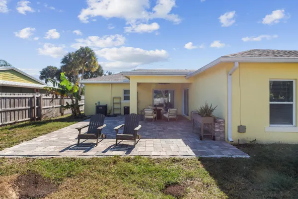 a view of a house with backyard water fountain and sitting area