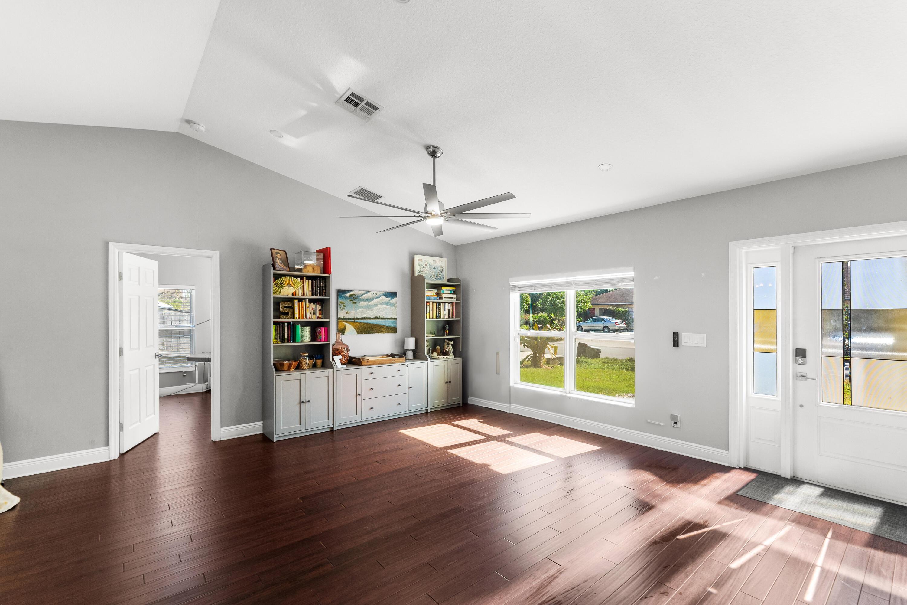 3037 Southeast Iris Street Stuart, FL 34997 - Photo 5 of 36 a view of an empty room with a window and wooden floor
