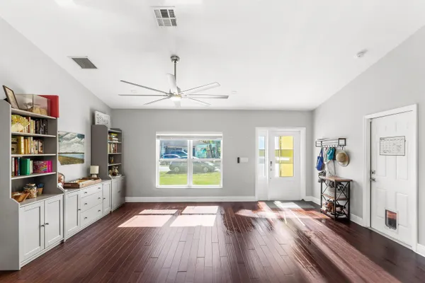 a view of empty room with wooden floor and window