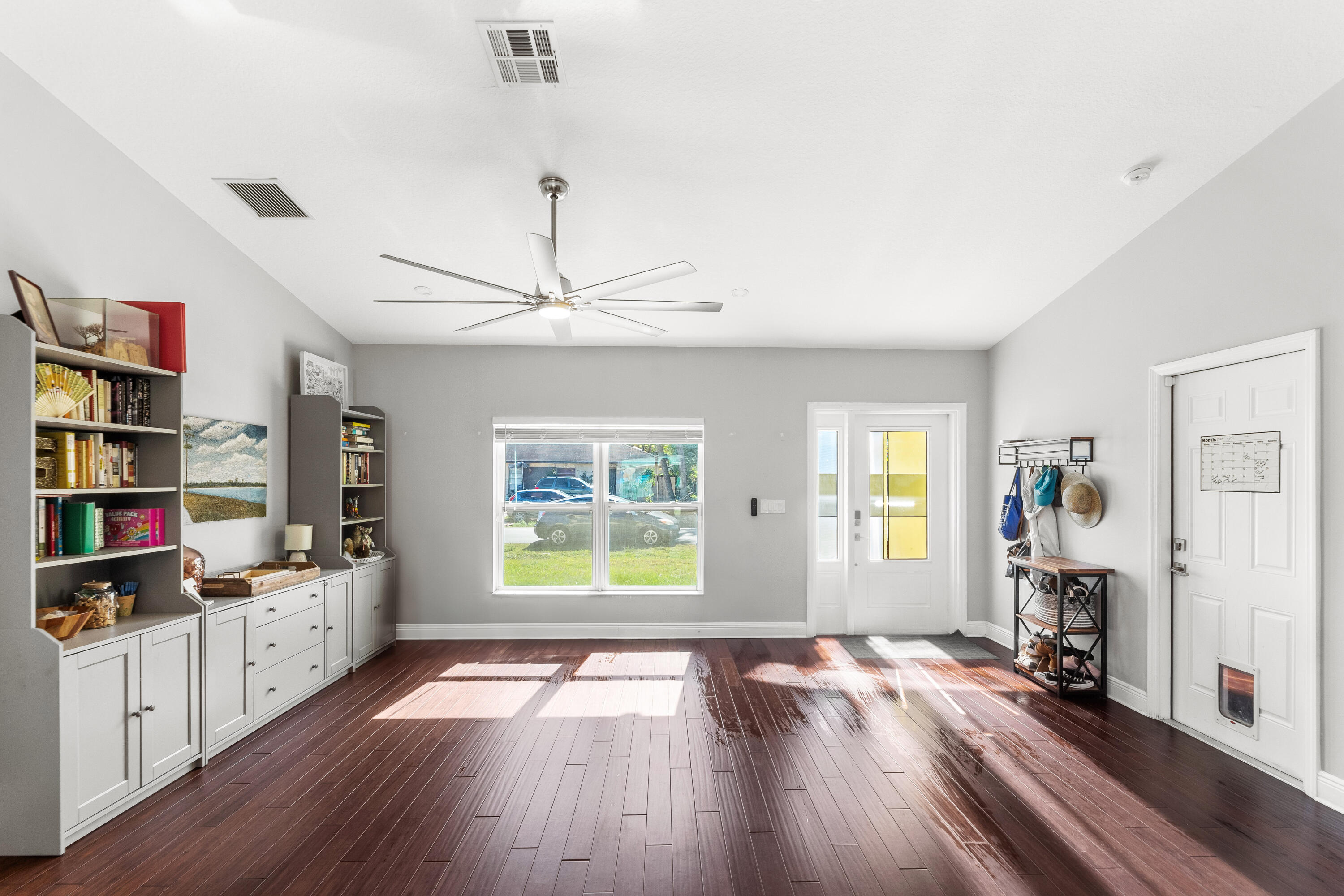 3037 Southeast Iris Street Stuart, FL 34997 - Photo 7 of 36 a view of empty room with wooden floor and window