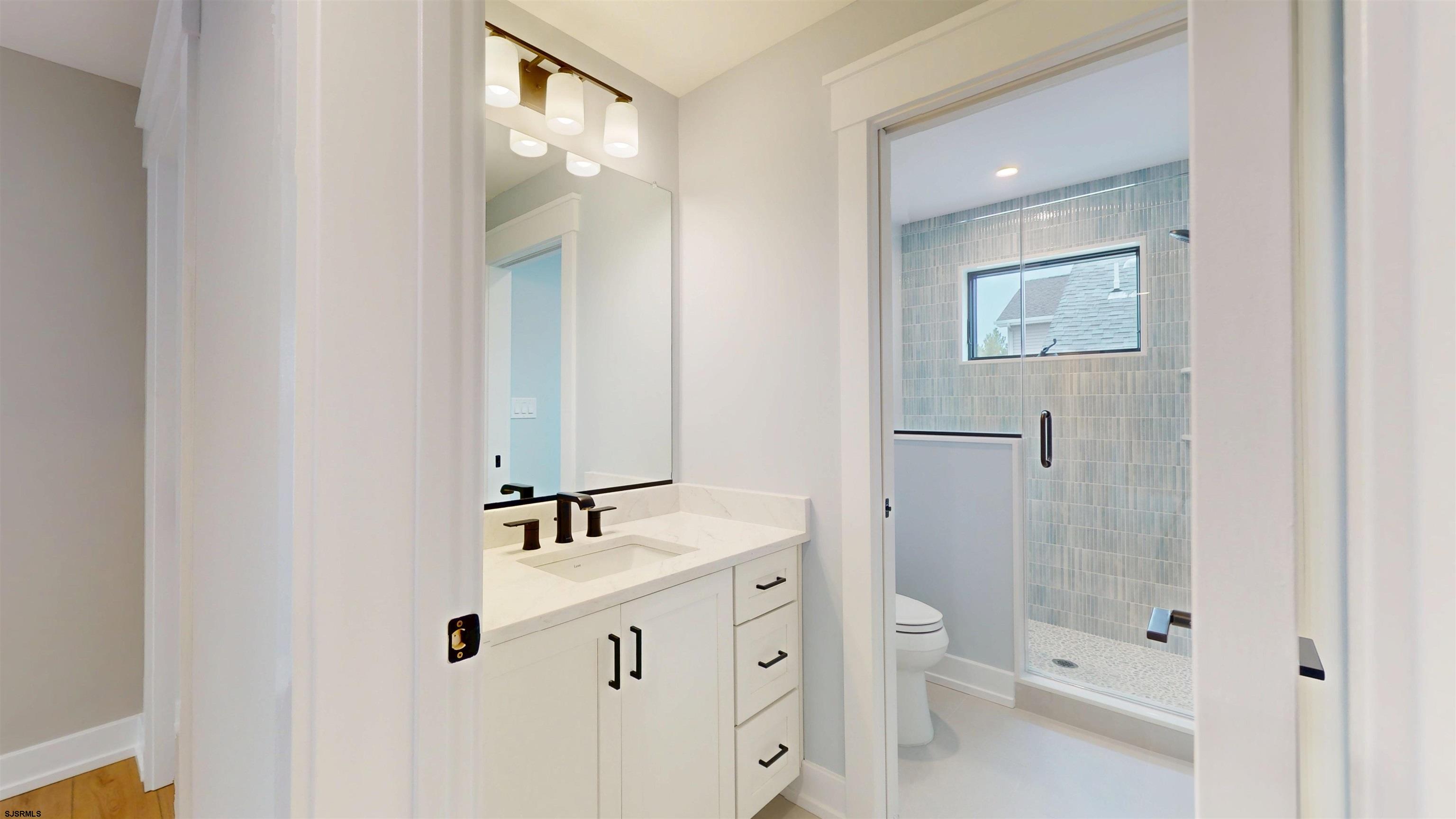 204 12th Street South Brigantine, NJ 08203 - Photo 40 of 63 a bathroom with a double vanity sink toilet and shower