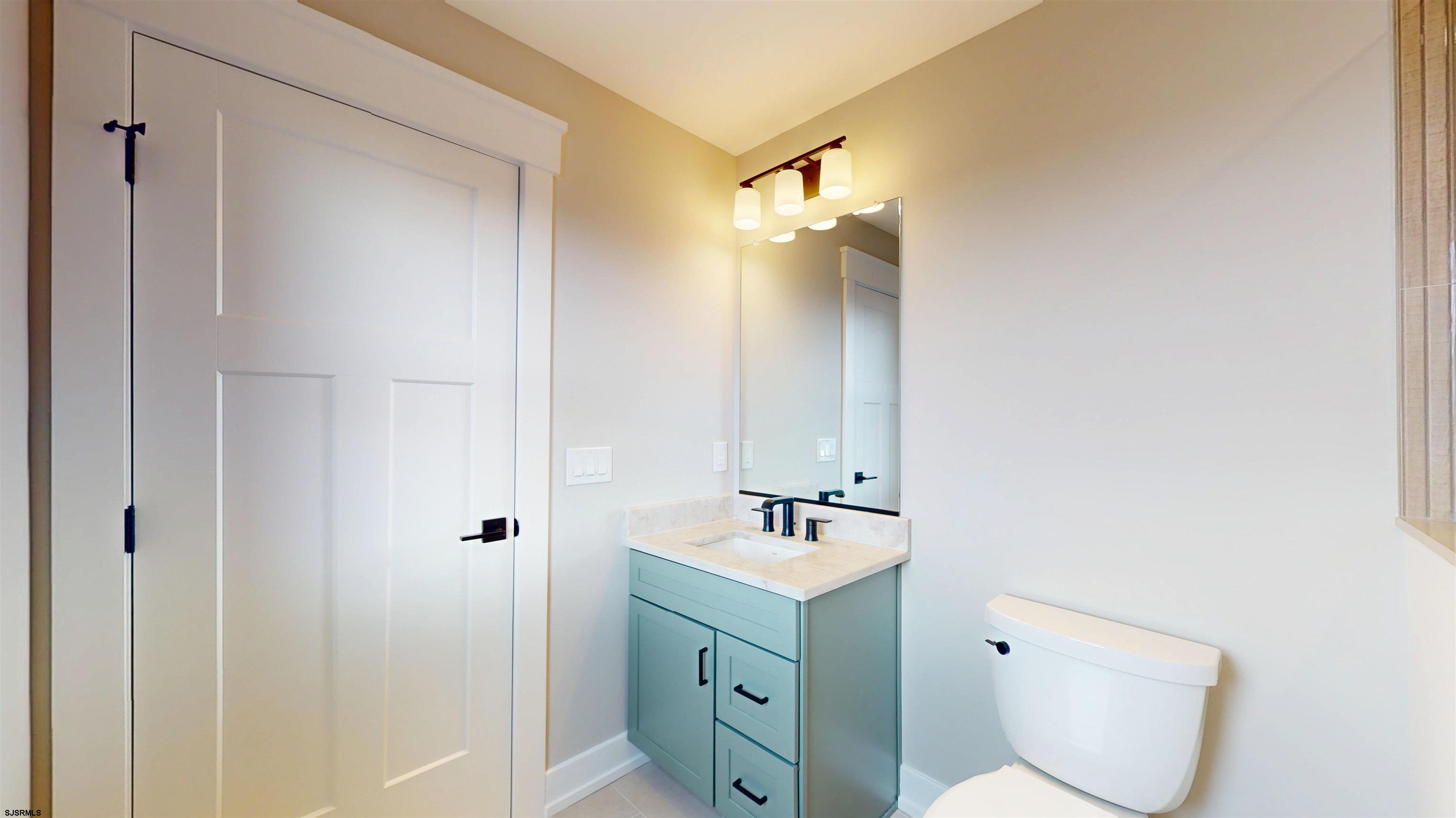 204 12th Street South Brigantine, NJ 08203 - Photo 45 of 63 a bathroom with a toilet sink and mirror