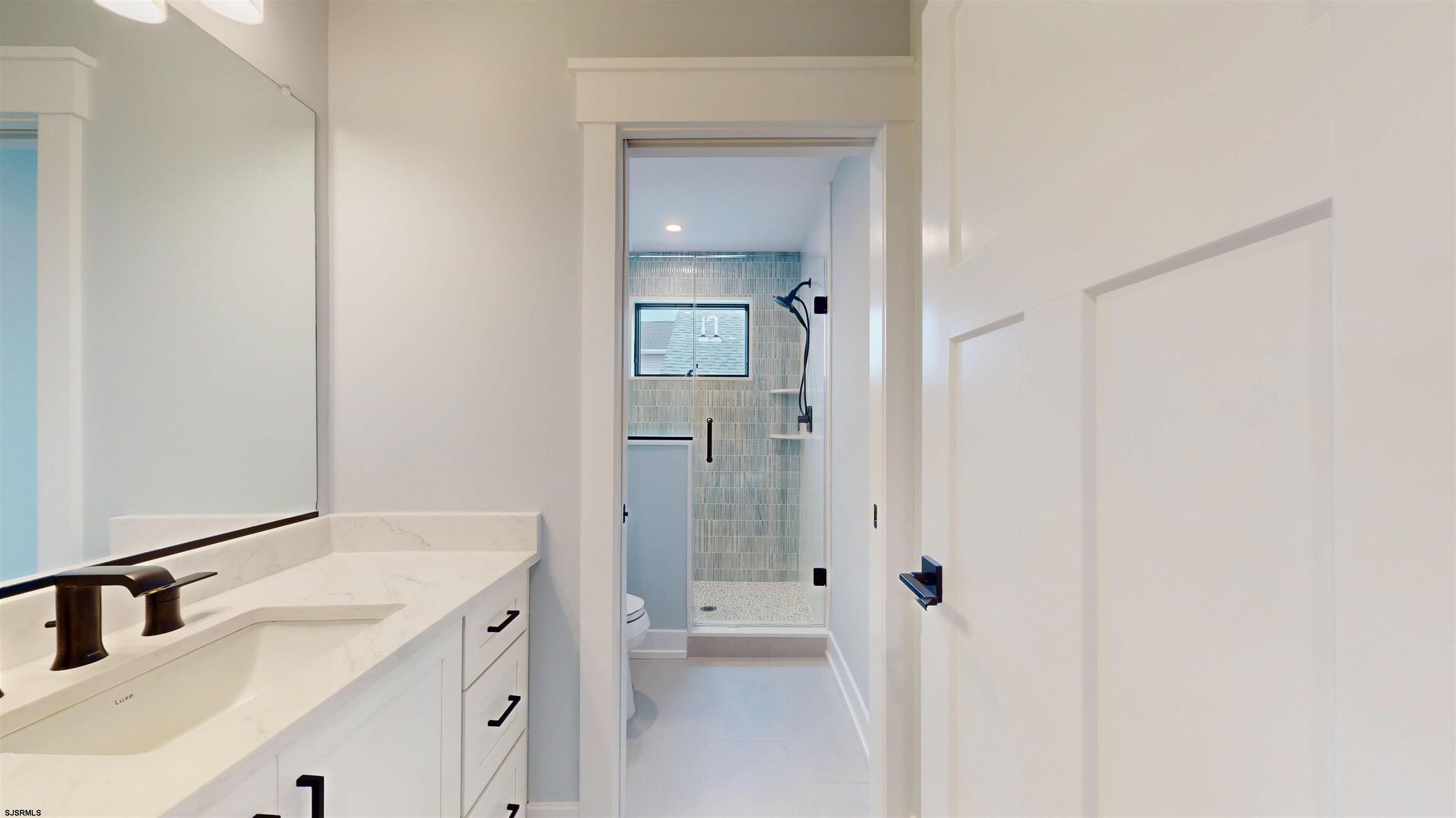 204 12th Street South Brigantine, NJ 08203 - Photo 47 of 63 a bathroom with a sink a toilet and shower
