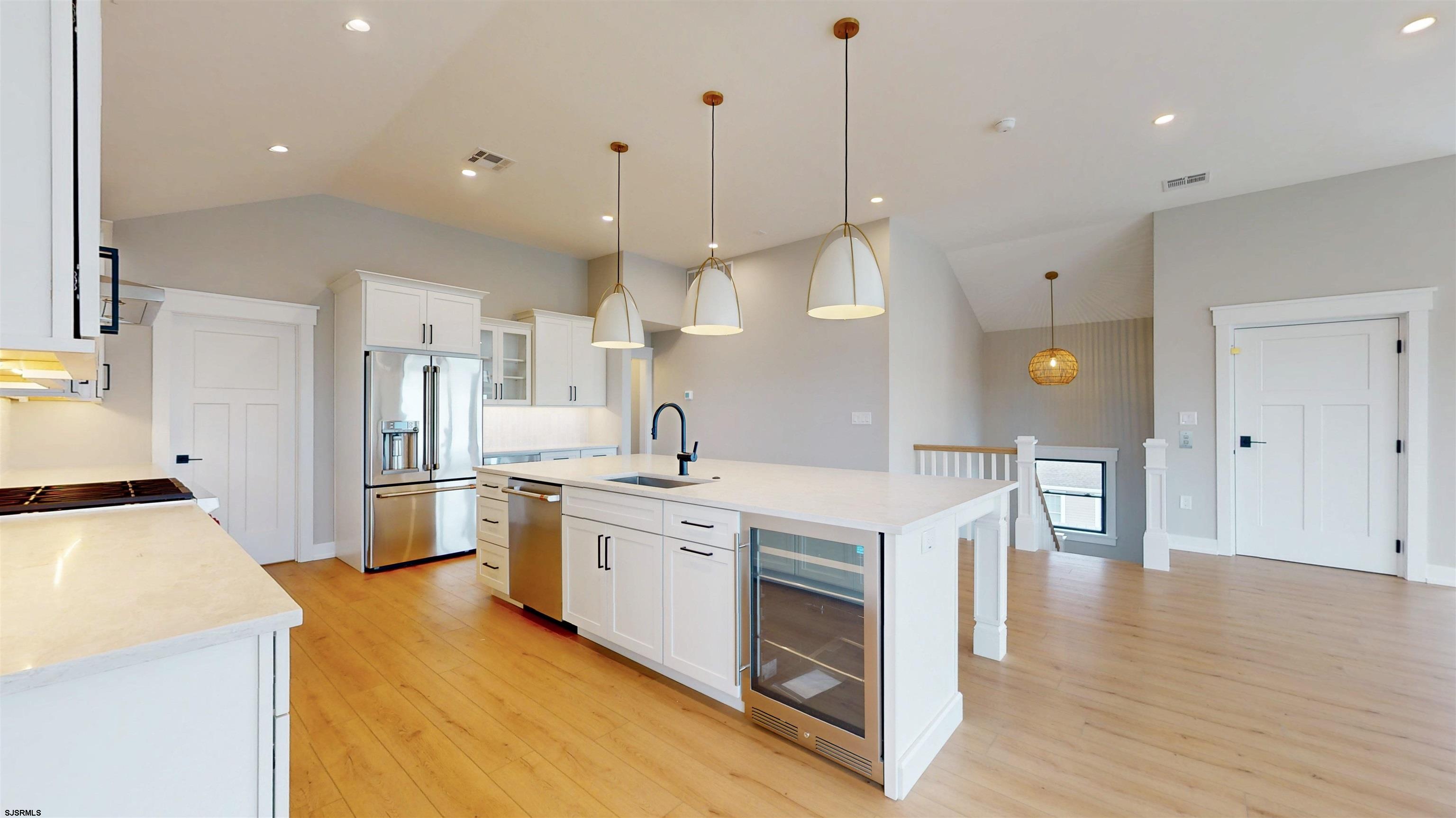 204 12th Street South Brigantine, NJ 08203 - Photo 6 of 63 a large kitchen with stainless steel appliances kitchen island a large counter top a sink a stove and a refrigerator