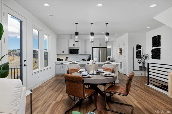 a kitchen with stainless steel appliances kitchen island granite countertop a table chairs microwave and cabinets