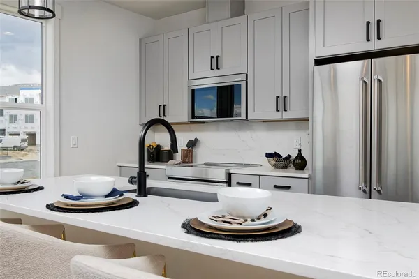 a kitchen with a stove and a white cabinet with wooden floor