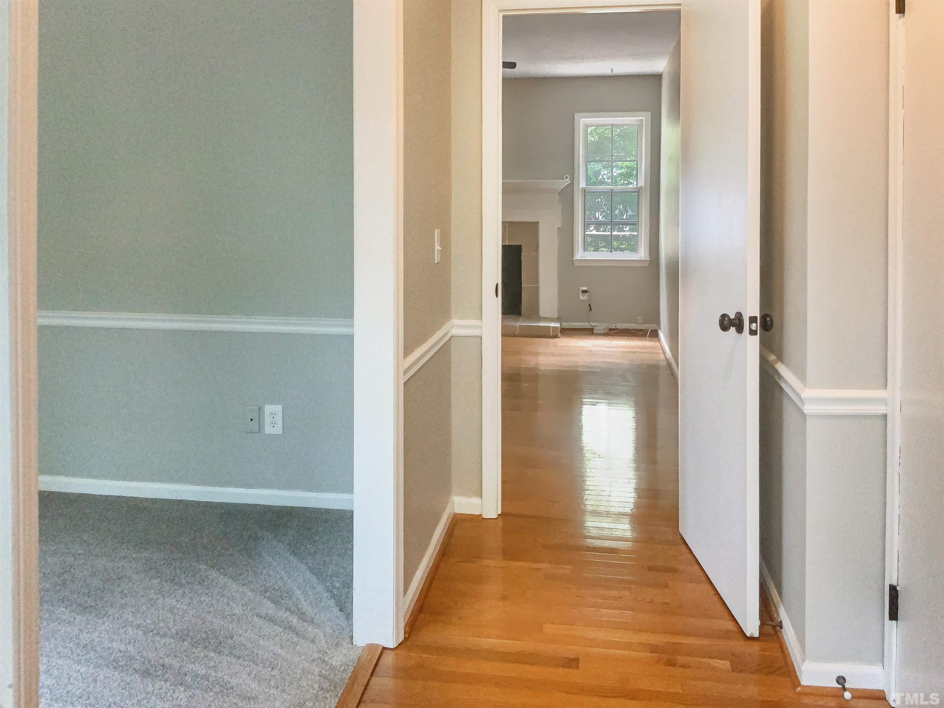 7312 Mine Valley Road Raleigh, NC 27615 - Photo 8 of 19 a view of a hallway with wooden floor and a bathroom
