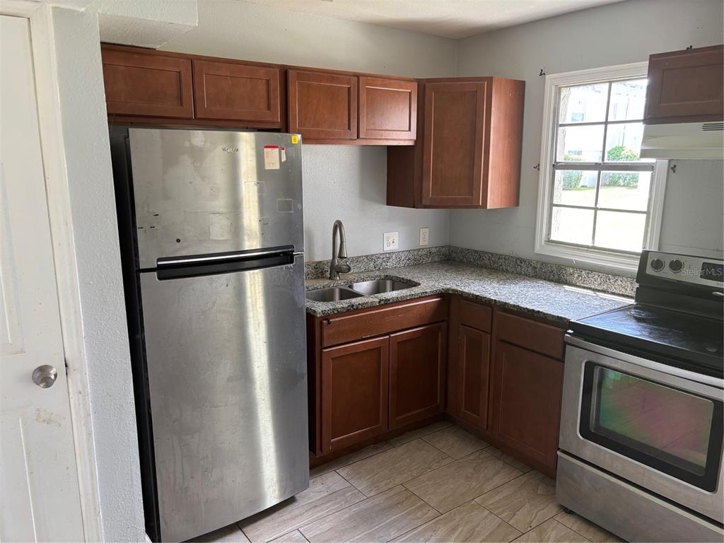 2779 L B McLeod Road, Unit A Orlando, FL 32805 - Photo 4 of 8 a kitchen with a refrigerator sink and cabinets