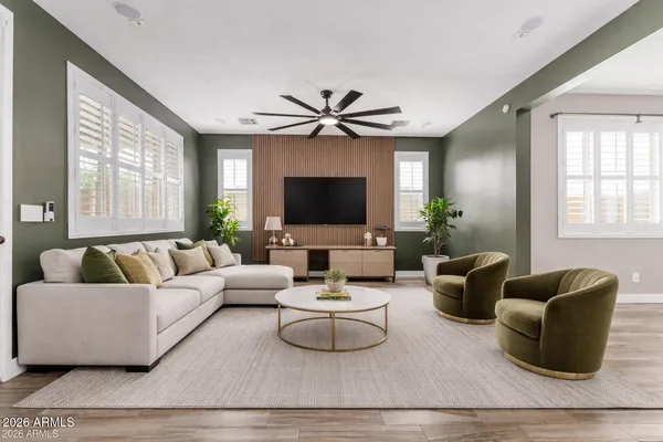 a living room with furniture a flat screen tv and a large window