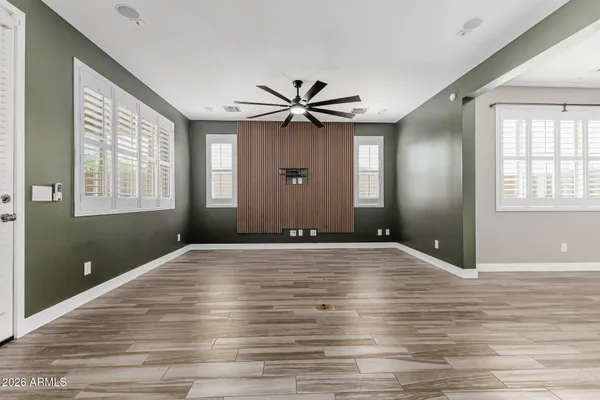 a view of an empty room with window and wooden floor