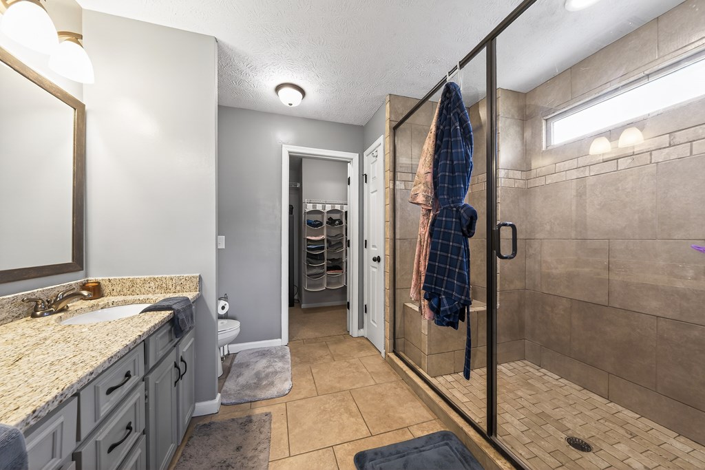 7333 Cedar Creek Loop Columbus, GA 31904 - Photo 19 of 37 a bathroom with a granite countertop sink a mirror and shower