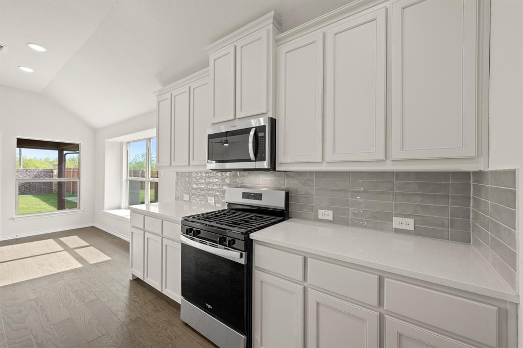 10809 Rothland Street Crowley, TX 76036 - Photo 2 of 30 a kitchen with granite countertop white cabinets stainless steel appliances and a window