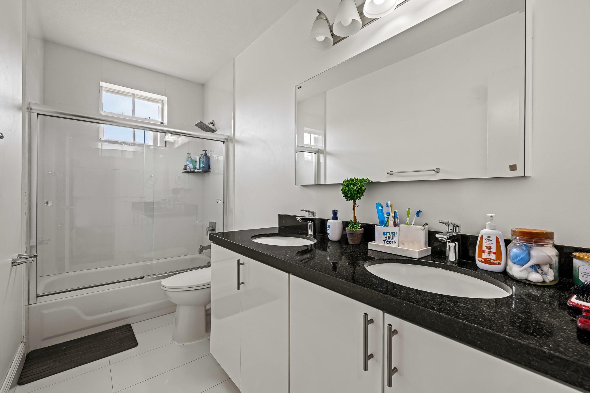 695 Falling Water Road Weston, FL 33326 - Photo 17 of 31 a bathroom with a granite countertop sink a toilet and shower