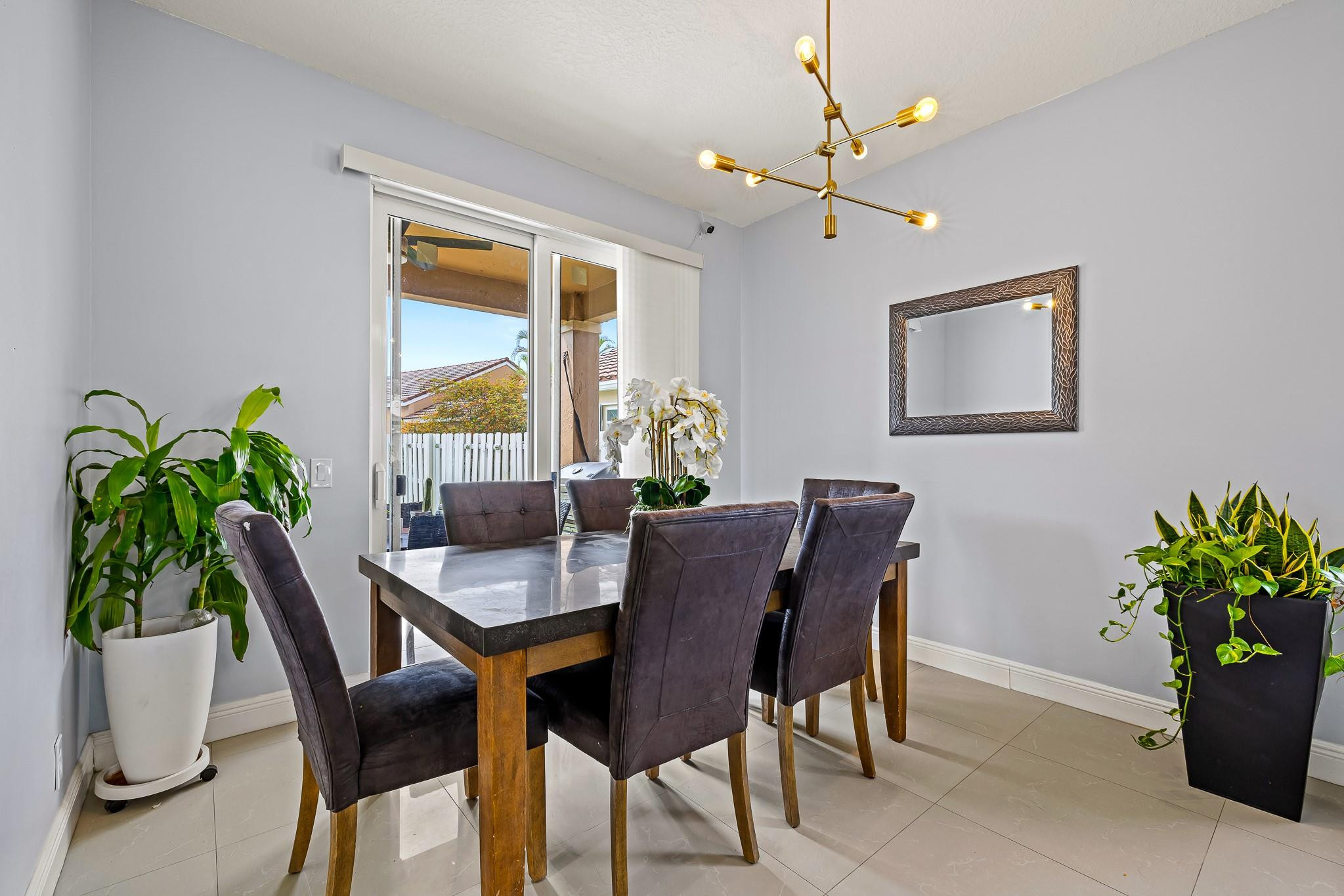 695 Falling Water Road Weston, FL 33326 - Photo 7 of 31 a dining room with furniture potted plants and wooden floor