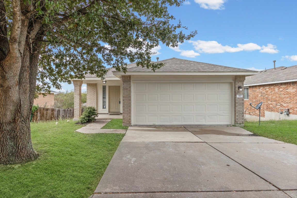 a view of a house with a yard and garage