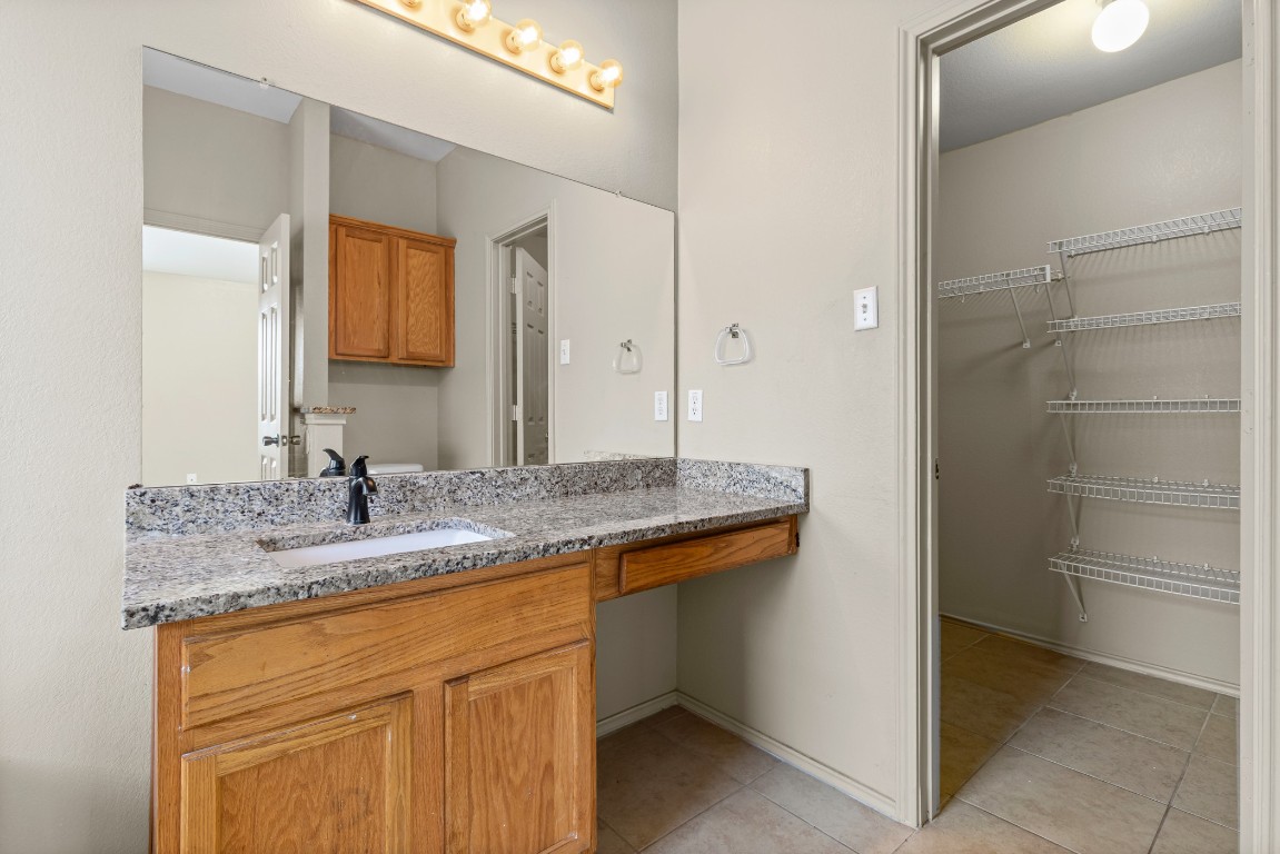 317 Tudor House Road Pflugerville, TX 78660 - Photo 13 of 28 a bathroom with a granite countertop sink and a mirror