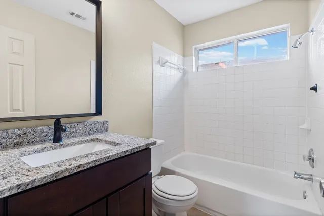 a bathroom with a granite countertop sink toilet and shower
