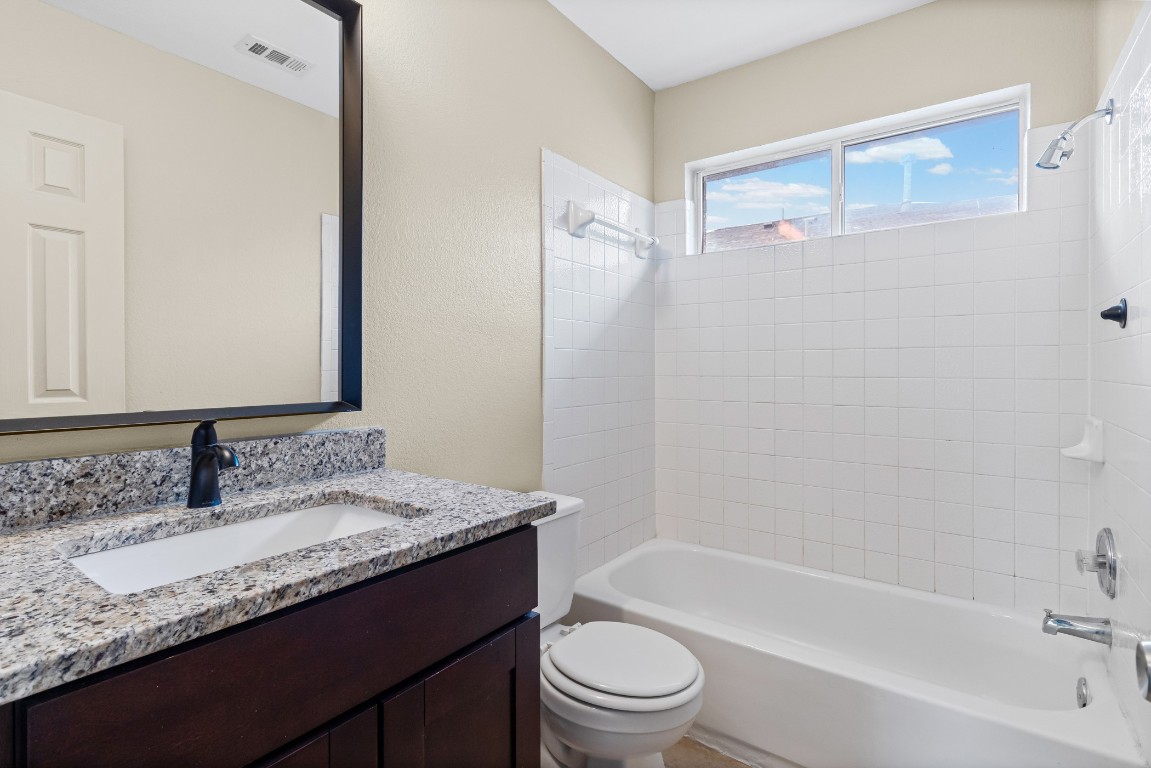 317 Tudor House Road Pflugerville, TX 78660 - Photo 17 of 28 a bathroom with a granite countertop sink toilet and shower