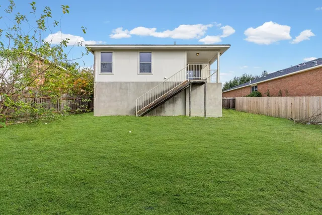 a view of a house with a yard and a tree