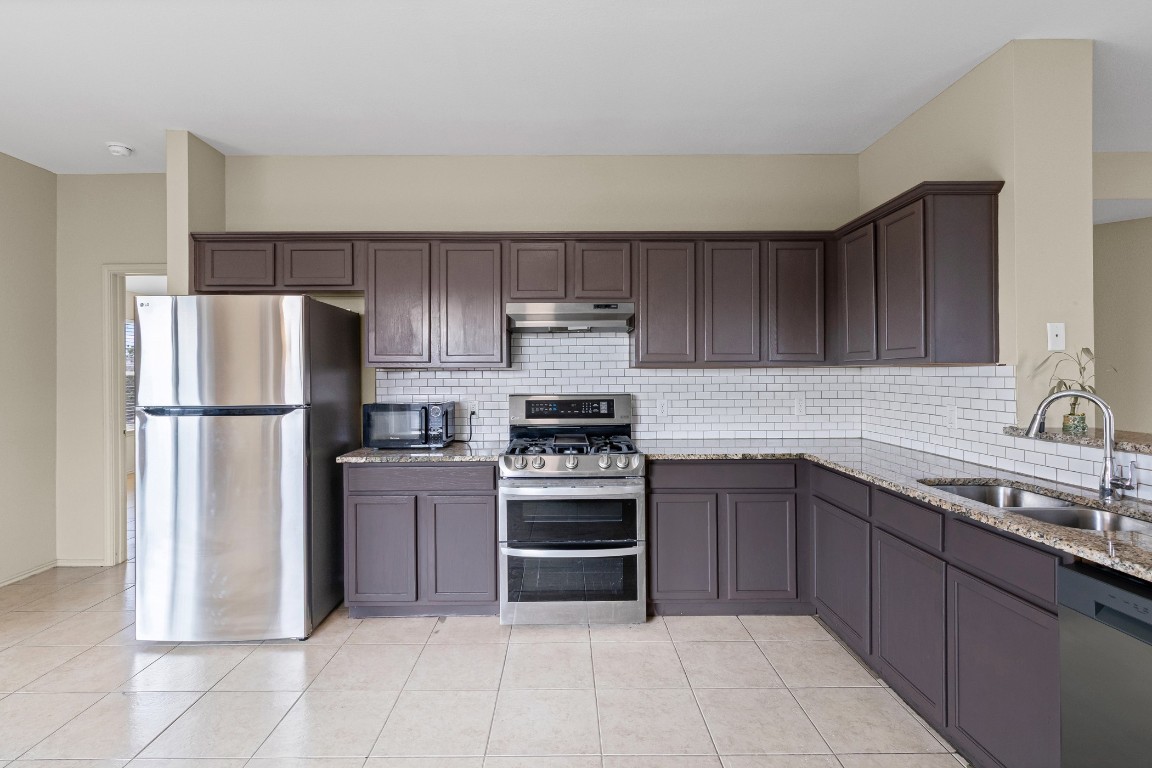 317 Tudor House Road Pflugerville, TX 78660 - Photo 6 of 28 a kitchen with a sink stove and refrigerator