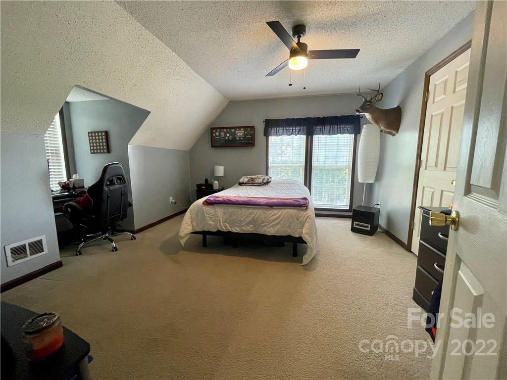 353 Duncan Road Rutherfordton, NC 28139 - Photo 26 of 42 a bedroom with a bed and a chandelier
