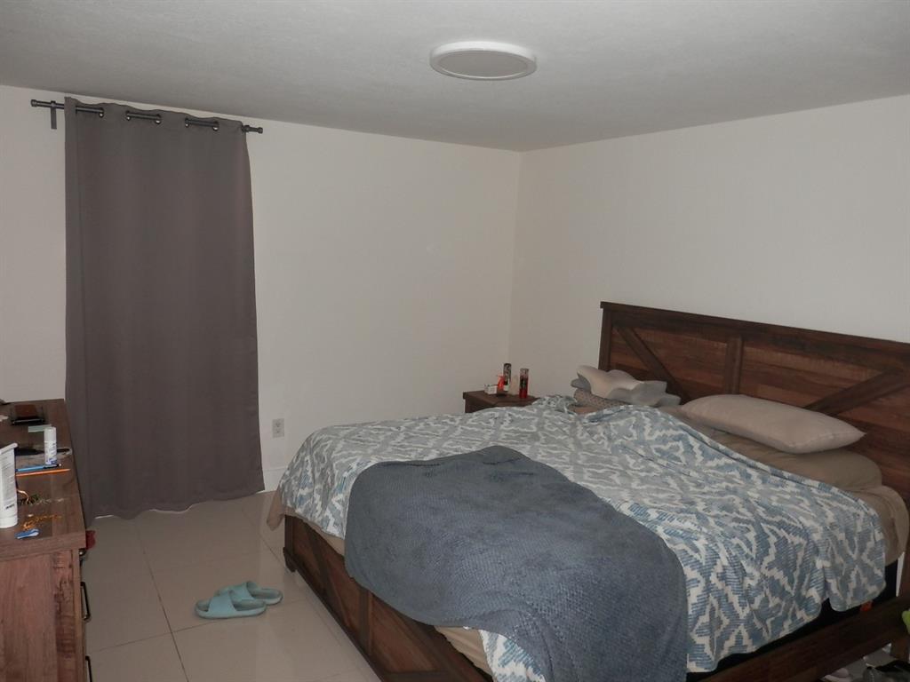 9459 Southwest 76th Street, Unit R1 Miami, FL 33173 - Photo 7 of 7 a bedroom with a bed and a window
