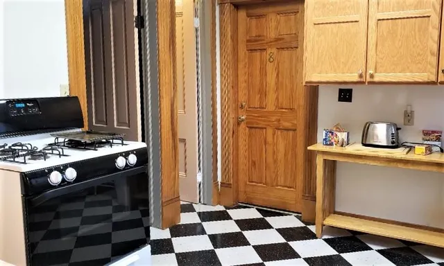 a view of a hallway with wooden floor and entryway