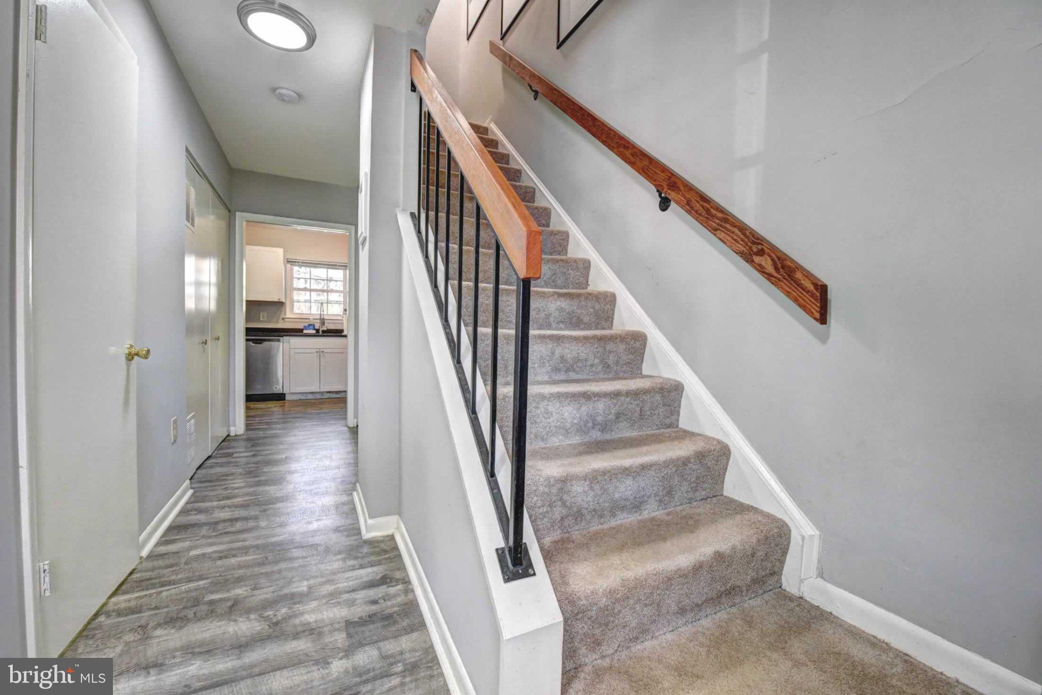 2226 Gunsmith Square Reston, VA 20191 - Photo 16 of 35 a view of staircase with lots of frames on wall and wooden floor