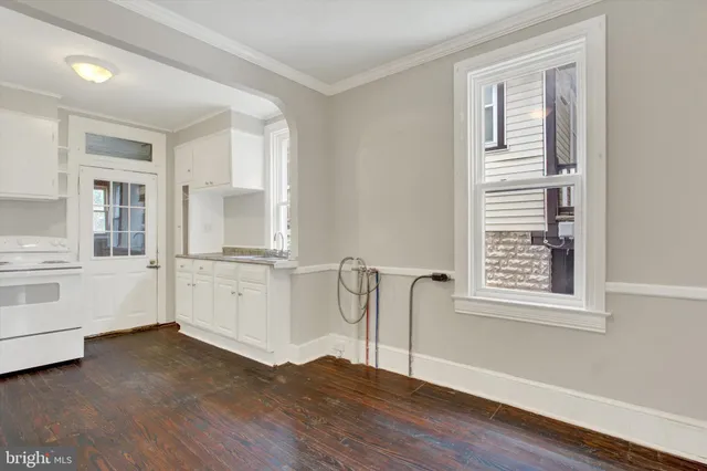 a view of empty room with window and wooden floor