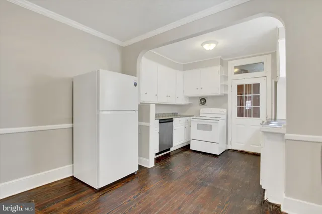a kitchen with white cabinets and white appliances