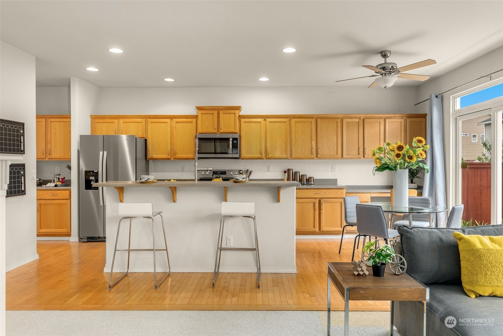 554 Rosario Avenue Northeast Renton, WA 98059 - Photo 9 of 38 a kitchen with stainless steel appliances granite countertop a stove a sink a refrigerator a dining table and chairs with wooden floor