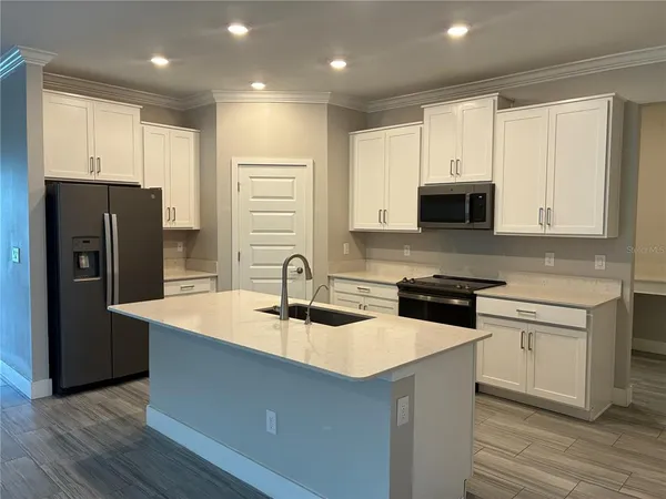 a kitchen with stainless steel appliances granite countertop a sink stove microwave and refrigerator