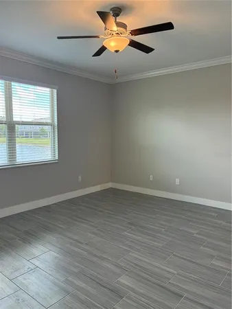 a view of an empty room with window and wooden floor