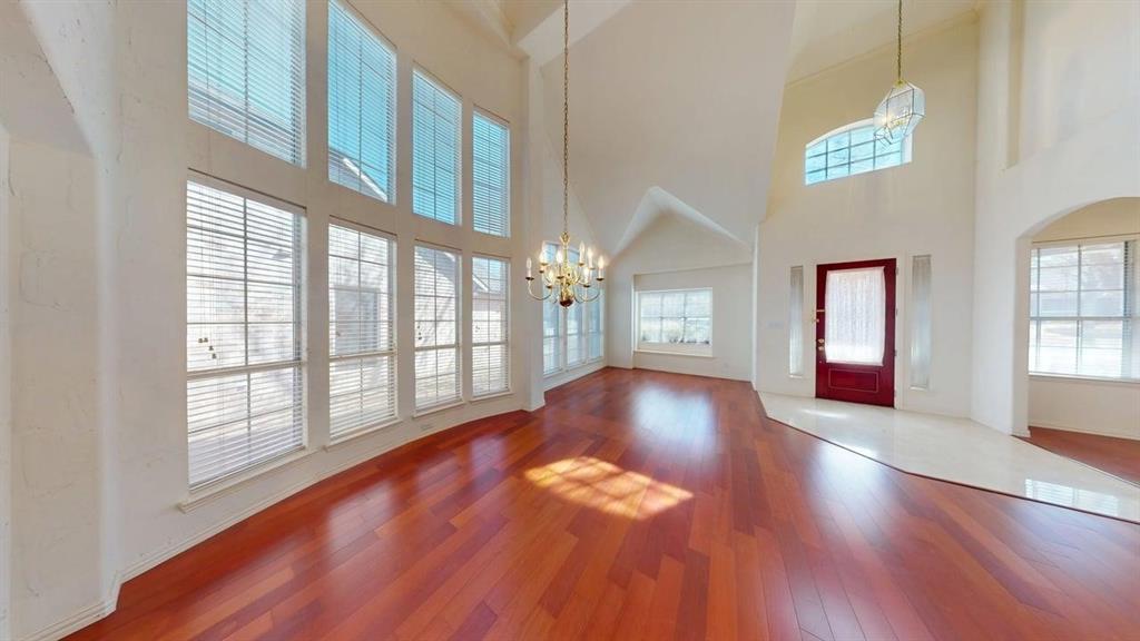 2022 Huntcliffe Court Allen, TX 75013 - Photo 9 of 40 Foyer entrance featuring hanging lights, hardwood / wood-style floors, and a high ceiling