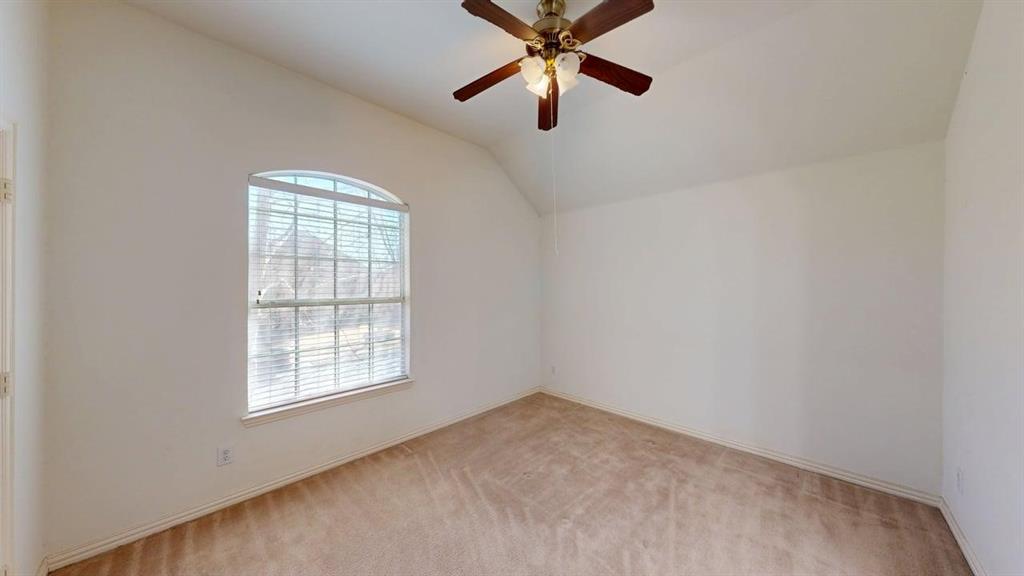 2022 Huntcliffe Court Allen, TX 75013 - Photo 19 of 40 Spare room featuring vaulted ceiling, light colored carpet, and a ceiling fan
