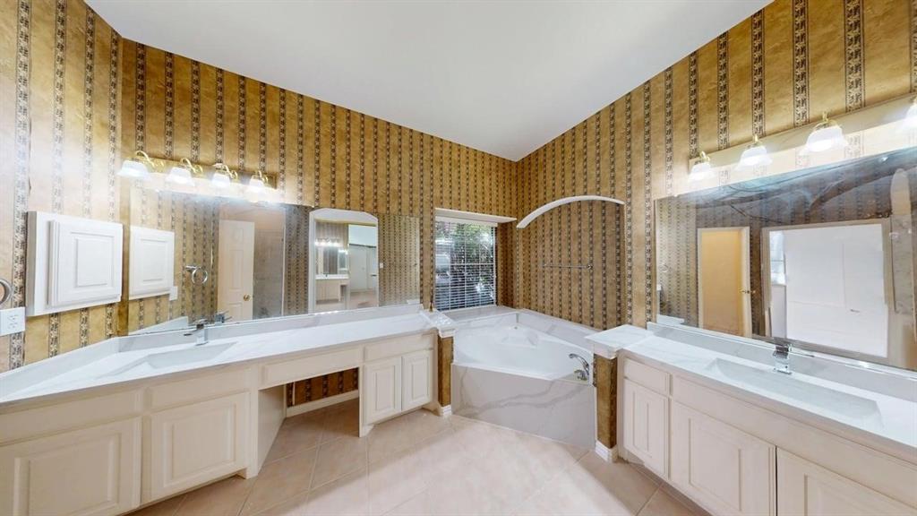 2022 Huntcliffe Court Allen, TX 75013 - Photo 29 of 40 Full bathroom with two vanities, a bath, light tile patterned floors, and wallpapered walls